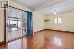 Spare room with wood-type flooring and beamed ceiling - 