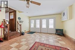 Foyer entrance featuring a wood stove, ceiling fan, stairs, recessed lighting, and light tile patterned floors - 