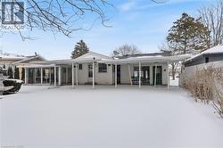 Snow covered property featuring a gate, a patio, and a sunroom - 