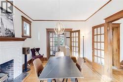 Dining room with french doors, ornamental molding, a fireplace, and wood finished floors - 