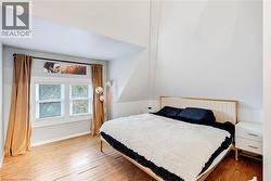 Bedroom featuring hardwood / wood-style flooring and baseboards - 