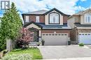 Two-story residence featuring a brick and stucco facade, a prominent arched window on the second level, a covered front entryway, and an attached two-car garage with paneling - 71 Jessica Street, Hamilton, ON  - Outdoor 