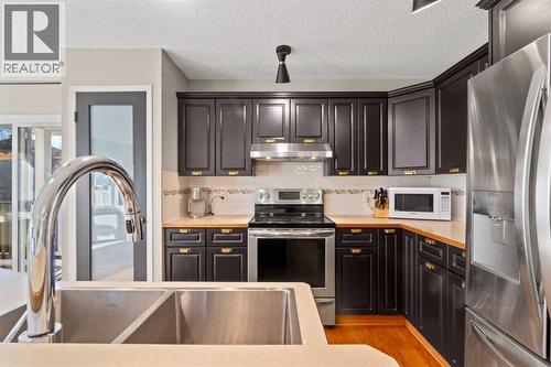 21 Wilson Road Ne, Langdon, AB - Indoor Photo Showing Kitchen With Stainless Steel Kitchen With Double Sink With Upgraded Kitchen