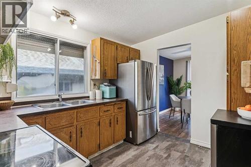 Kitchen with large bright window - 23 Dovercliffe Way Se, Calgary, AB - Indoor Photo Showing Kitchen With Double Sink