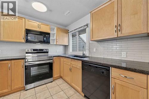 211, 25 Glamis Green Sw, Calgary, AB - Indoor Photo Showing Kitchen With Double Sink