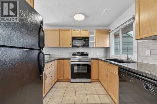 211, 25 Glamis Green Sw, Calgary, AB - Indoor Photo Showing Kitchen With Double Sink