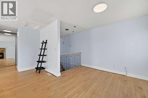 211, 25 Glamis Green Sw, Calgary, AB - Indoor Photo Showing Other Room With Fireplace