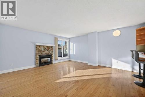 211, 25 Glamis Green Sw, Calgary, AB - Indoor Photo Showing Living Room With Fireplace
