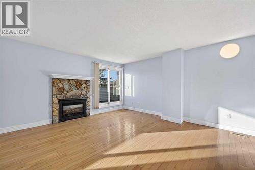 211, 25 Glamis Green Sw, Calgary, AB - Indoor Photo Showing Other Room With Fireplace