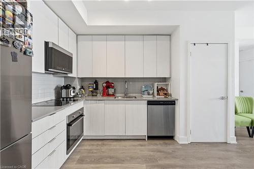 Kitchen featuring stainless steel appliances, light wood-style flooring, tasteful backsplash, and modern cabinets - 297 Oak Walk Drive Unit# 2407, Oakville, ON - Indoor Photo Showing Kitchen