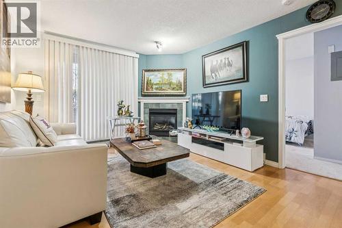 105, 15320 Bannister Road Se, Calgary, AB - Indoor Photo Showing Living Room With Fireplace