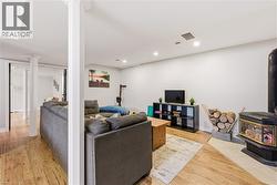 Living room with a wood stove, light wood-style floors, and recessed lighting - 