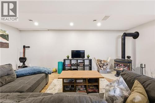 Living room with a wood stove, wood finished floors, and recessed lighting - 230 Saugeen Street, Grey Highlands, ON - Indoor Photo Showing Basement
