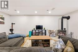 Living room with a wood stove, wood finished floors, and recessed lighting - 