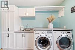 Laundry area featuring washing machine and clothes dryer and cabinet space - 