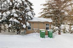 Snow covered structure featuring a shed - 