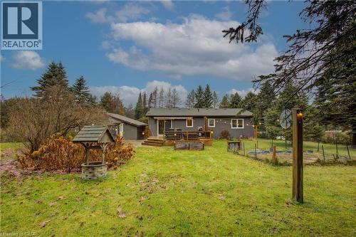 Rear view of house with a wooden deck, a yard, a vegetable garden, and view of scattered trees - 230 Saugeen Street, Grey Highlands, ON - Outdoor With Deck Patio Veranda
