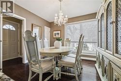 Dining space featuring dark wood finished floors, a chandelier, and healthy amount of natural light - 