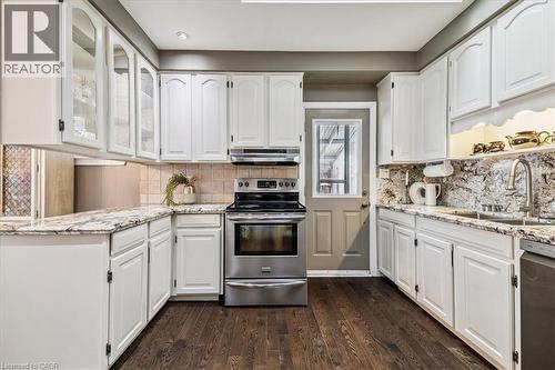 Kitchen with stainless steel appliances, white cabinets, light stone counters, glass insert cabinets, and recessed lighting - 359 Pepper Drive, Burlington, ON - Indoor Photo Showing Kitchen With Upgraded Kitchen