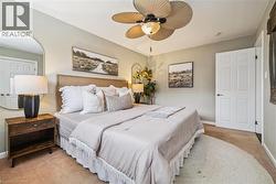 Carpeted bedroom featuring baseboards and ceiling fan - 