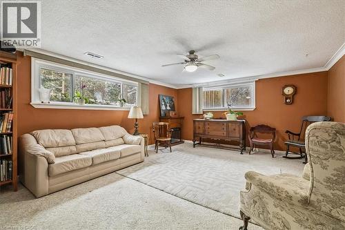 Carpeted living area featuring crown molding, a textured ceiling, and a ceiling fan - 359 Pepper Drive, Burlington, ON - Indoor Photo Showing Living Room