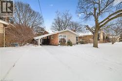 Snow covered property featuring brick siding and a chimney - 