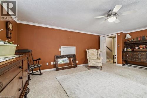 Living area featuring light colored carpet, crown molding, a textured ceiling, ceiling fan, and stairs - 359 Pepper Drive, Burlington, ON - Indoor Photo Showing Other Room
