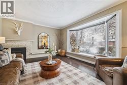 Sitting room with ornamental molding, a fireplace, dark wood finished floors, and a textured ceiling - 