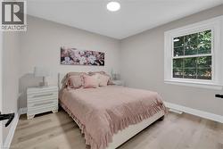 Bedroom with light wood-style flooring and baseboards - 