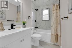 Full bathroom featuring vanity, light marble finish flooring, and a combined bath / shower with marble appearance - 