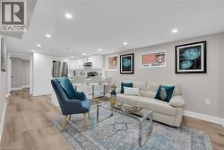 Living area with light wood-style flooring and recessed lighting - 