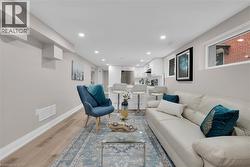 Living area with light wood-style floors and recessed lighting - 