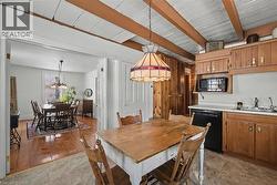 Dining room with a chandelier and a wooden ceiling with exposed beams - 