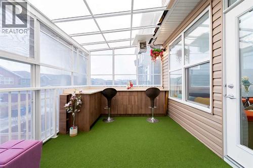 A sunroom adjacent to the main-level living and dining areas... - 99 Evansglen Circle Nw, Calgary, AB - Outdoor With Exterior