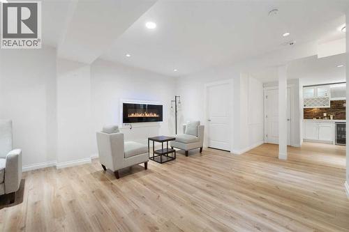 A spacious basement offering endless possibilities—enjoy movie nights with friends or convert it into a legal basement suite (subject to City approval) to generate additional income - 99 Evansglen Circle Nw, Calgary, AB - Indoor With Fireplace