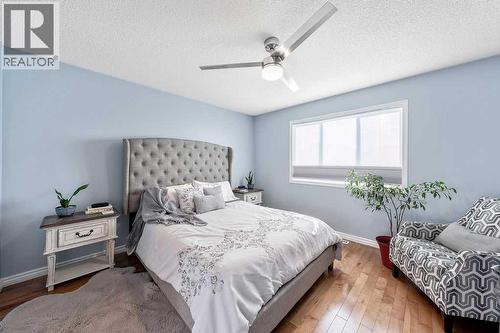 The generously sized primary bedroom offers a calm and comfortable retreat - 361 Cimarron Boulevard, Okotoks, AB - Indoor Photo Showing Bedroom