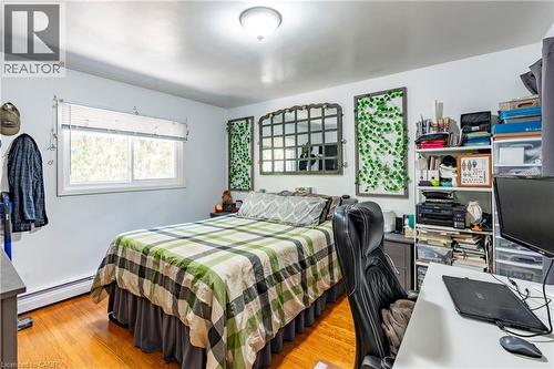 Bedroom with light wood finished floors, a baseboard heating unit, and an office area - 62 Moore Avenue, Kitchener, ON - Indoor Photo Showing Bedroom