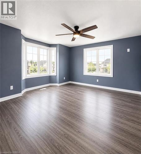 Spacious room featuring wood-finish flooring, a contemporary ceiling fan with integrated lighting, and a bay window with white trim - 22 Todd Crescent, Dundalk, ON - Indoor Photo Showing Other Room