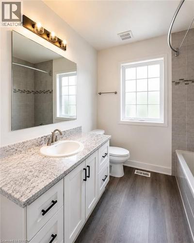 Bathroom featuring a white shaker-style vanity with dark hardware, a rectangular undermount sink, and a speckled countertop - 22 Todd Crescent, Dundalk, ON - Indoor Photo Showing Bathroom