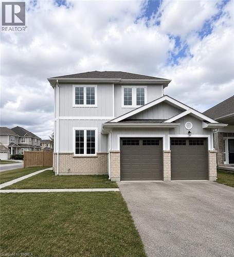 Two-story residence featuring light gray vertical siding and a partial brick facade - 22 Todd Crescent, Dundalk, ON - Outdoor With Facade