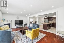 Living room featuring light wood-style floors, a fireplace, recessed lighting, and a textured ceiling - 