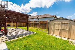 Fenced backyard featuring a pergola, a shed, and a patio area - 