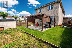 Rear view of house with a pergola, a patio, a fenced backyard, a residential view, and stone siding - 