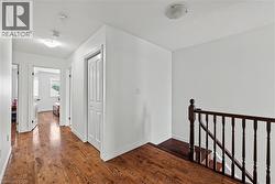 Hallway featuring an upstairs landing and dark wood-style flooring - 