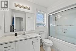 Bathroom featuring vanity, enclosed tub / shower combo, and light tile patterned flooring - 