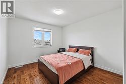 Bedroom featuring dark wood-type flooring and baseboards - 