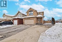 Traditional home featuring driveway, an attached garage, and brick siding - 