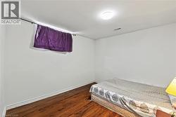 Bedroom with dark wood finished floors and baseboards - 