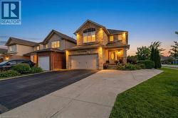 View of front of home with driveway, an attached garage, a front lawn, and brick siding - 