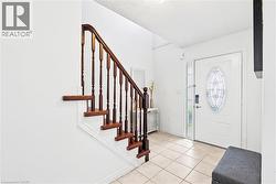 Foyer entrance featuring light tile patterned floors, stairway, and a textured ceiling - 